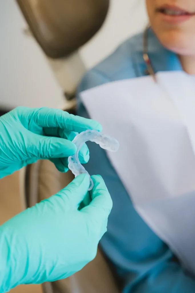 Dentiste présentant une gouttière transparente à une patiente avant un traitement orthodontique