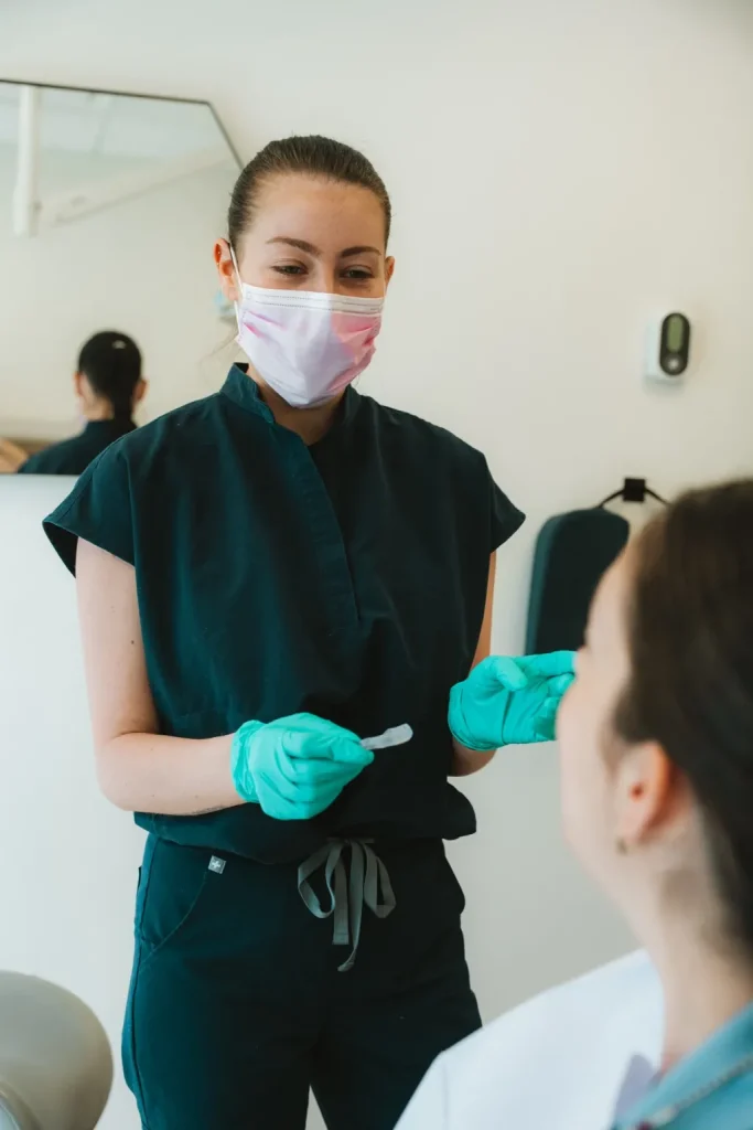 Hygiéniste dentaire préparant une patiente avant un nettoyage des dents