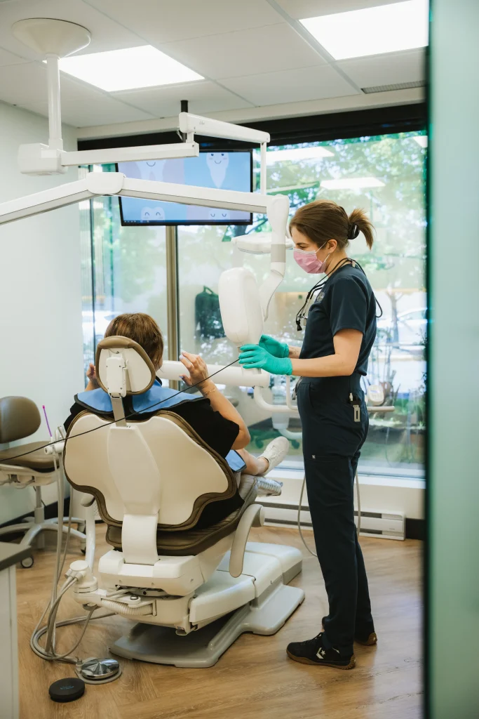 Hygiéniste dentaire préparant une patiente pour une radiographie panoramique en clinique