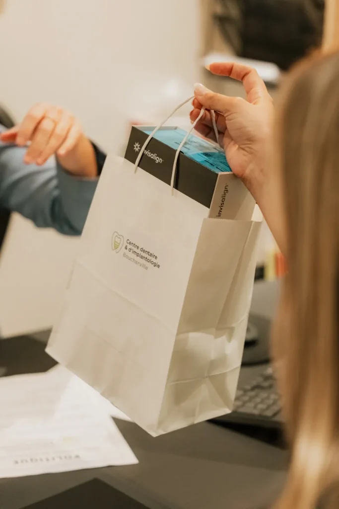 Patient recevant sa boîte Invisalign et son plan de traitement en clinique dentaire