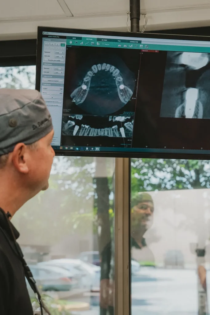 Dentiste analysant une imagerie 3D des dents sur un écran de diagnostic